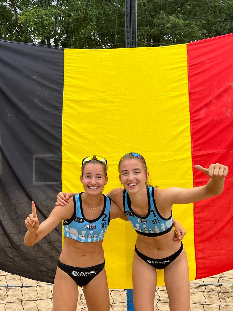 Beachvolleyball tournament winning picture in front of the Belgian flag at the wevza u19 in Bilthoven in 2023.